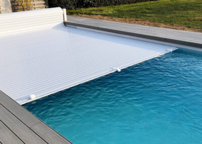 Installation d'une piscine coque avec volet immergé entourée d’une terrasse en composite