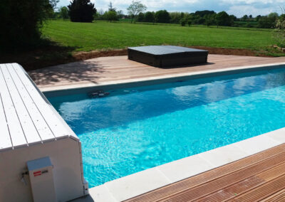 Rénovation totale d’une piscine avec terrasse en bois exotique, margelle, spa et volet banc