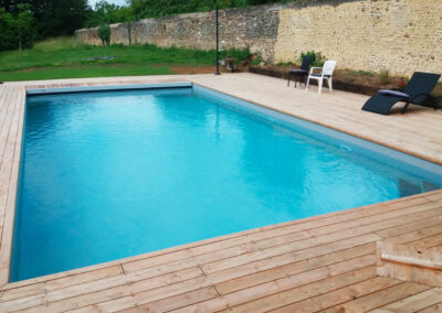 Piscine maçonnée de 10 x 5 m avec membrane gris clair, escalier d’angle et volet immergé