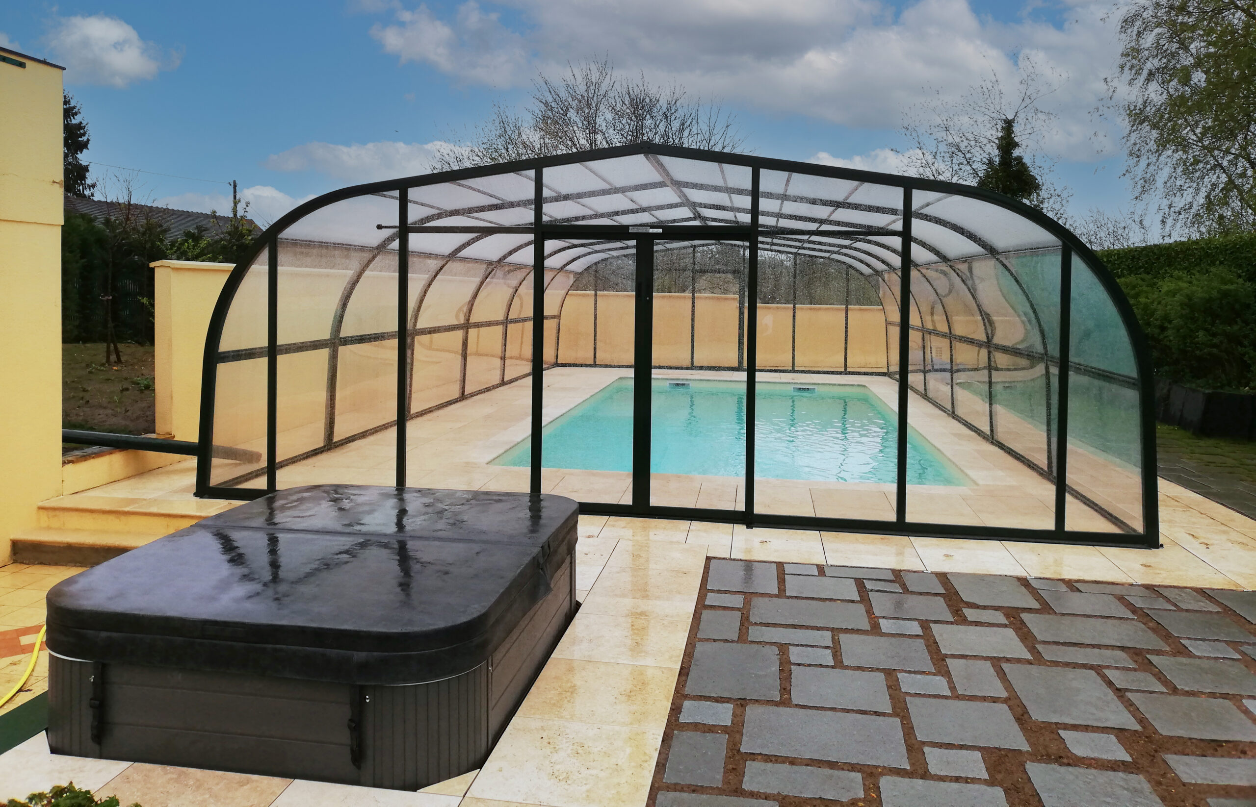 Rénovation totale d'une piscine avec abris haut Carla, terrasse sur plots en grès cérame et installation d'un spa