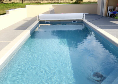 Piscines extérieure avec escalier d'angle et volet roulant